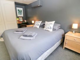 A bedroom with a double bed and bedside table at Well Cottage Nr Malmesbury