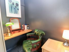 A study with a green chair and a desk at Well Cottage Nr Malmesbury