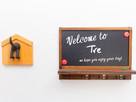 A welcome sign and decorative hooks in the entryway at Carines Barns - Tre