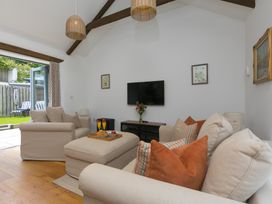 A living room with a sofa and coffee table at Carines Barns - Tre in Cubert