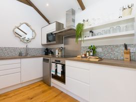 A kitchen with cabinets and appliances at Carines Barns - Tre in Cubert