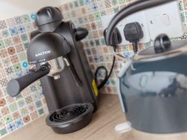 An espresso machine and kettle on a countertop at Carines Barns - Tre in Cubert