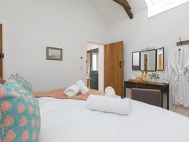 A bedroom with a bed and dressing table at Carines Barns - Tre in Cubert