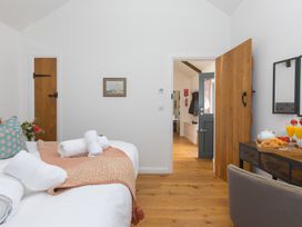 A bedroom with a bed and a table at Carines Barns - Tre in Cubert