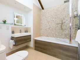 A bathroom with a shower, sink, and bathtub at Carines Barns - Tre, Cubert