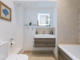 A bathroom with a sink and mirror at Carines Barns - Tre in Cubert