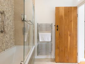 A bathroom with a tub and towel rack at Carines Barns - Tre in Cubert