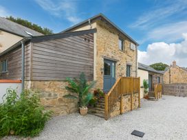 An outdoor area with a stone building and wooden steps at Carines Barns - Pen, Cubert