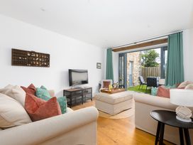 A living room with a television and soft seating area at Carines Barns - Pen, Cubert