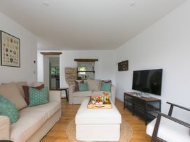 A living room with a sofa and television at Carines Barns - Pen in Cubert