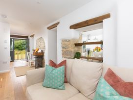 A living room with a sofa and cushions at Carines Barns - Pen, Cubert