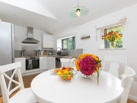 A kitchen with a table and fruit bowl at Carines Barns - Pen, Cubert