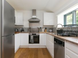 A kitchen with modern appliances and wooden countertop at Carines Barns - Pen in Cubert