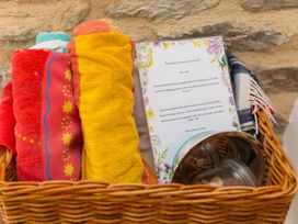 A basket with towels and a welcome note at Carines Barns - Pen, Cubert