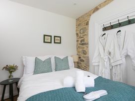 A bedroom with a bed and decorative items at Carines Barns - Pen, Cubert