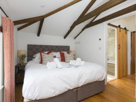 A bedroom with a bed and nightstand at Carines Barns - Pen in Cubert
