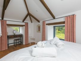 A bedroom with a bed and a desk at Carines Barns - Pen, Cubert