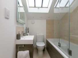 A bathroom with a sink, toilet, and bathtub at Carines Barns - Cubert