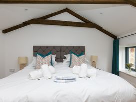 A bedroom with a large bed and pillows at Carines Barns - Pen in Cubert