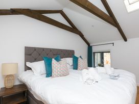 A bedroom with a bed and nightstand at Carines Barns - Pen, Cubert