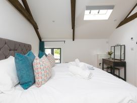 A bedroom with a bed, pillows, and a window at Carines Barns - Pen, Cubert