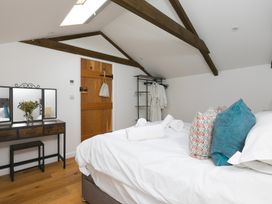 A bedroom with a bed and mirror at Carines Barns - Pen in Cubert