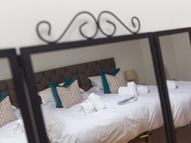 A bedroom with a bed and decorative pillows at Carines Barns - Pen, Cubert