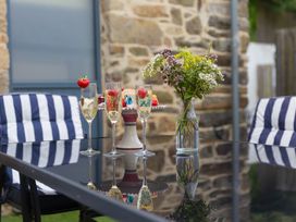 An outdoor seating area with champagne glasses and a cake at Carines Barns - Pen, Cubert