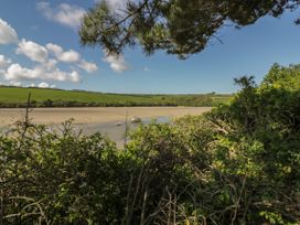 A view of water with a boat and green hills at Carines Barns - Pen, Cubert