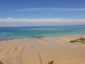A beach with people walking on the sand at Carines Barns - Pen, Cubert