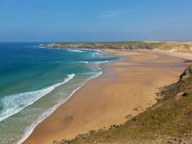 A beach with sand and waves at Carines Barns - Cubert
