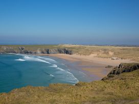 A beach landscape with ocean waves and cliffs at Carines Barns - Par, Cubert