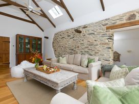 A living room with a sofa and coffee table at Carines Barns - Wesley Barn, Cubert