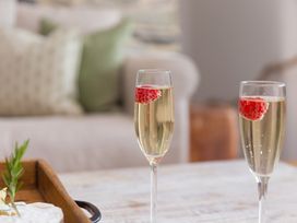 A tray with champagne glasses and strawberries at Carines Barns - Wesley Barn, Cubert