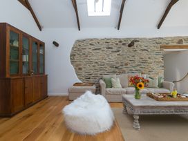 A living room with a sofa and coffee table at Carines Barns - Wesley Barn, Cubert