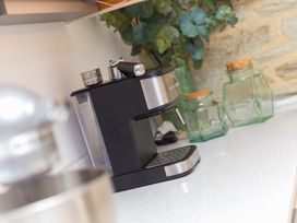 A coffee machine and glass containers on a countertop at Carines Barns - Wesley Barn, Cubert