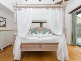 A bedroom with a four-poster bed and chest of drawers at Carines Barns - Wesley Barn, Cubert