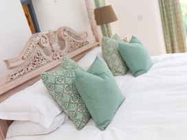 A bedroom with a bed and pillows at Carines Barns - Wesley Barn, Cubert