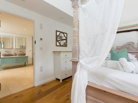 A bedroom with a bed and adjoining bathroom at Carines Barns - Wesley Barn in Cubert
