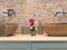 A bathroom with stone sinks and a flower pot at Carines Barns - Wesley Barn, Cubert