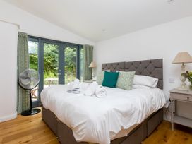 A bedroom with a bed and bedside table at Carines Barns - Wesley Barn in Cubert