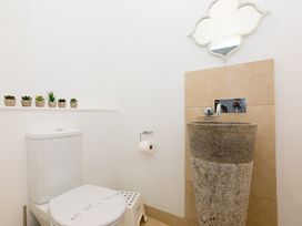 A bathroom with a toilet and a sink at Carines Barns - Wesley Barn, Cubert