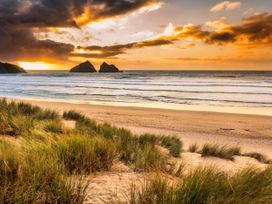 A beach scene with dunes and ocean at Carines Barns - Wesley Barn in Cubert