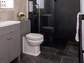 A bathroom featuring a toilet, sink, cabinet, and shower at Lower Mill in Dittisham