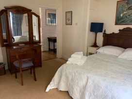 A bedroom with a bed and dressing table at Lower Mill in Dittisham