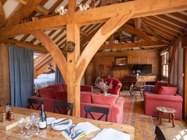 A living room with a dining table and sofas at The Barn in Dittisham