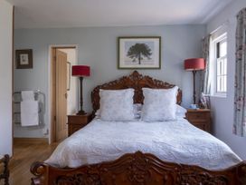 A bedroom with a bed, bedside table and lamp at Wisteria Suite in Dittisham