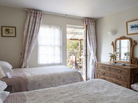 A bedroom with two beds and a dressing table at Wisteria Suite in Dittisham
