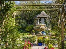 A garden with a fountain and pavilion at Wisteria Suite Dittisham