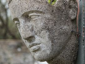A sculpture of a head outdoors at Wisteria Suite in Dittisham